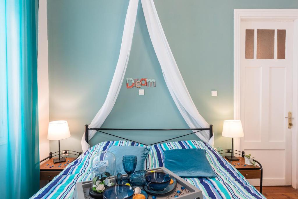 a bed with a canopy with a tray of food on it at Alegria rooms in Athens