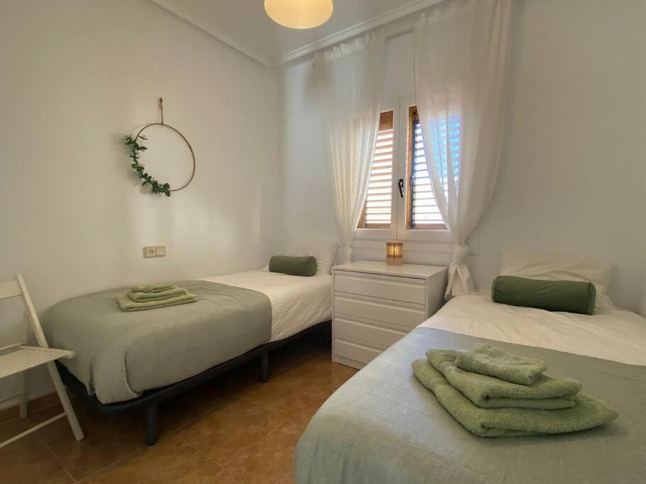 sypialnia z 2 łóżkami i lustrem na ścianie w obiekcie Tesoro del Eden w mieście Torrevieja