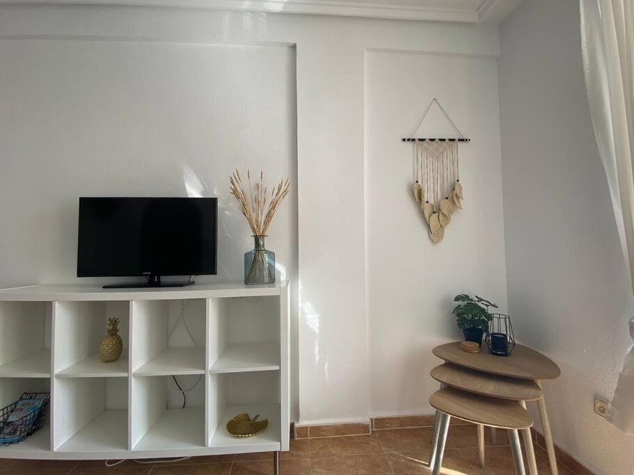 salon z telewizorem na białej półce w obiekcie Tesoro del Eden w mieście Torrevieja