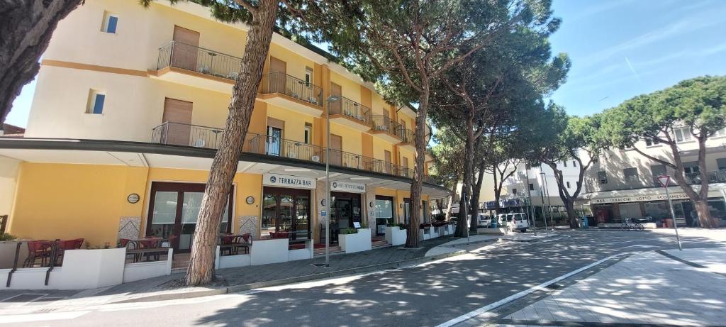 un edificio amarillo al lado de una calle en Hotel Residence Mara, en Lido di Jesolo