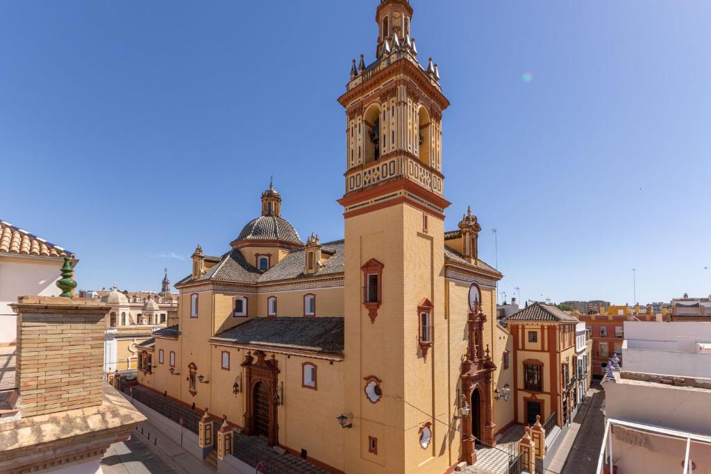ein altes Gebäude mit einem Turm darüber in der Unterkunft New! Ohliving San Bernardo in Sevilla