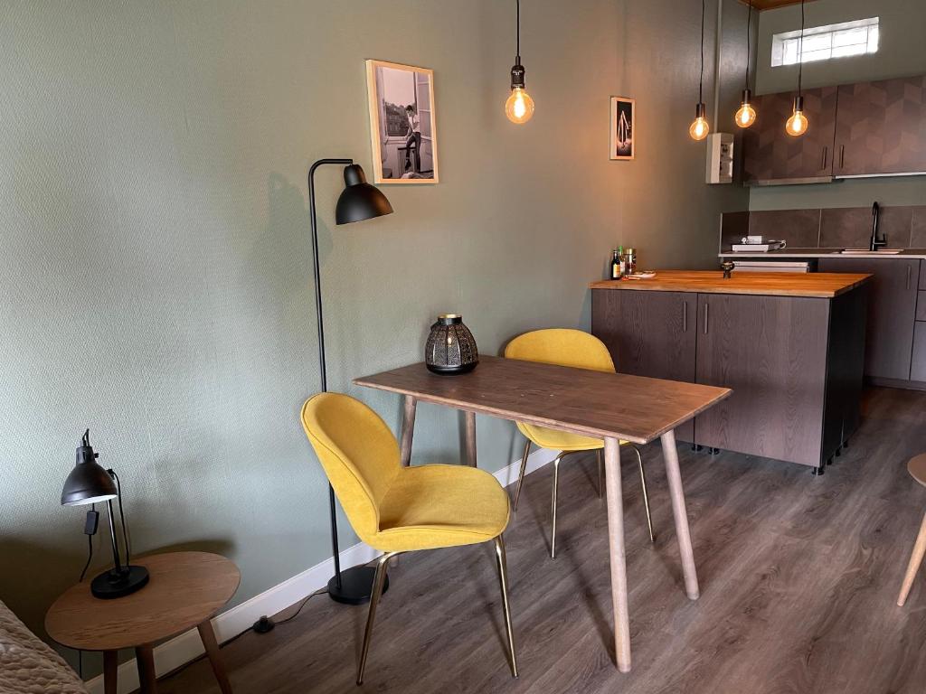 a kitchen with a table and two yellow chairs at Jonstrupvejens Apartments Lejl C in Ballerup