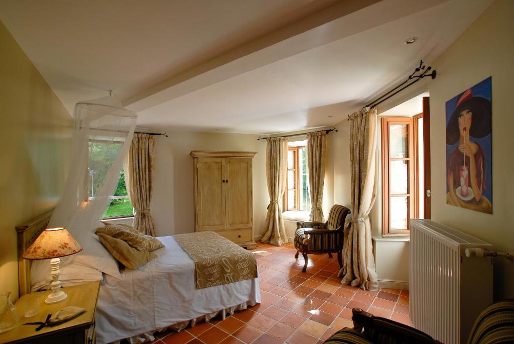 a bedroom with a bed and a table with a lamp at Moulin De Larcy in Ribérac