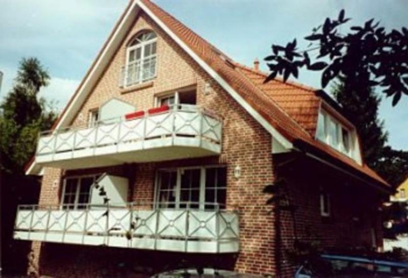 a large brick house with a white balcony at Appartementhaus Christiansen in Timmendorfer Strand