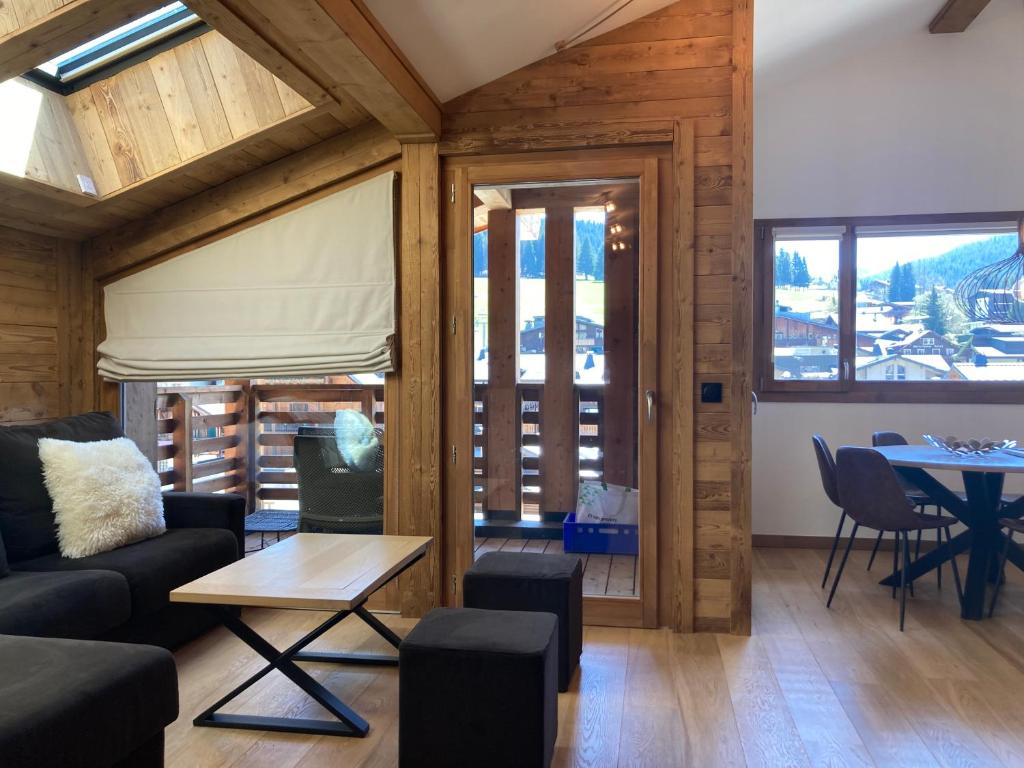 a living room with a couch and a table at Le Lodge Chasse Montagne in Les Gets