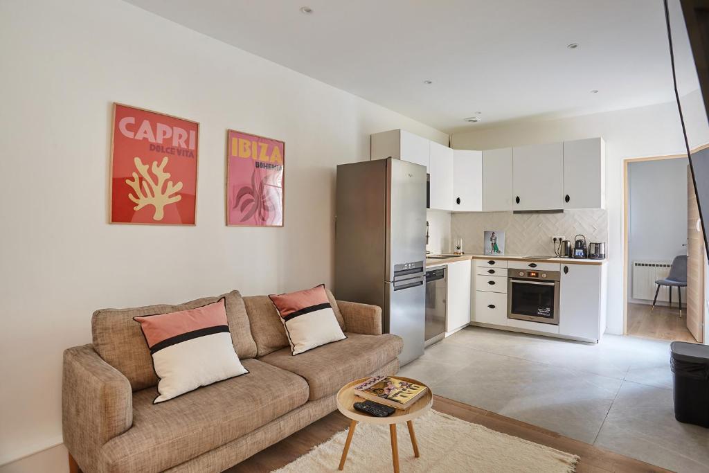 a living room with a couch and a kitchen at Apartment Parc des expositions by Studio prestige in Paris