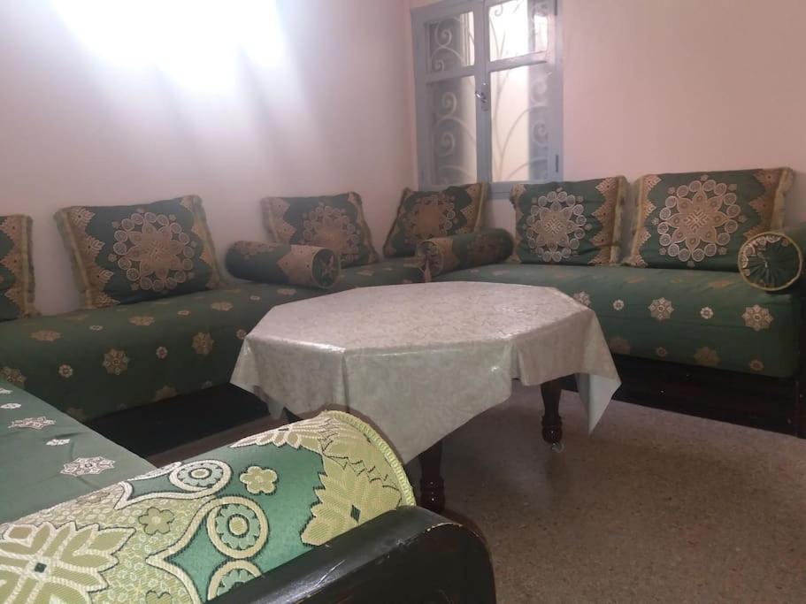 ein Wohnzimmer mit einem Sofa und einem Tisch in der Unterkunft Oisis Mazagan 2 in El Jadida