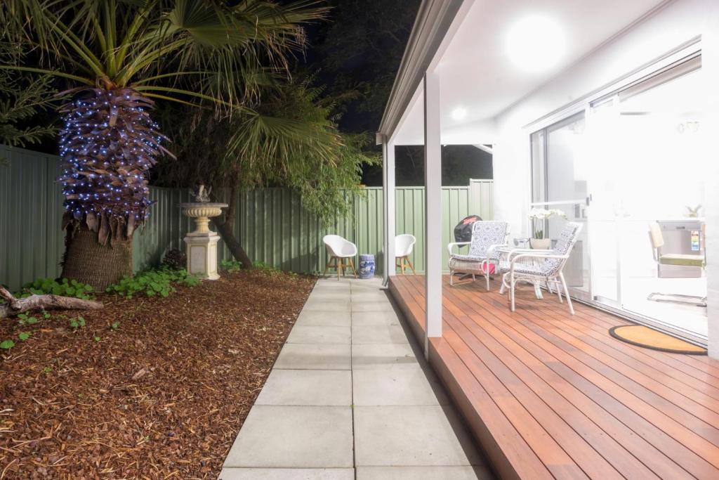 a porch with a wooden deck with a table and chairs at Beautiful Pet Friendly 1BR Cottage with Patio in Perth