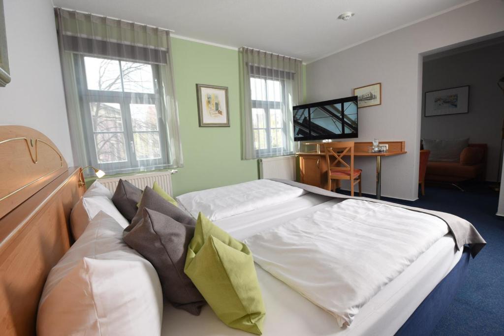 a bedroom with a large bed and a television at Hotel Anna Amalia in Weimar