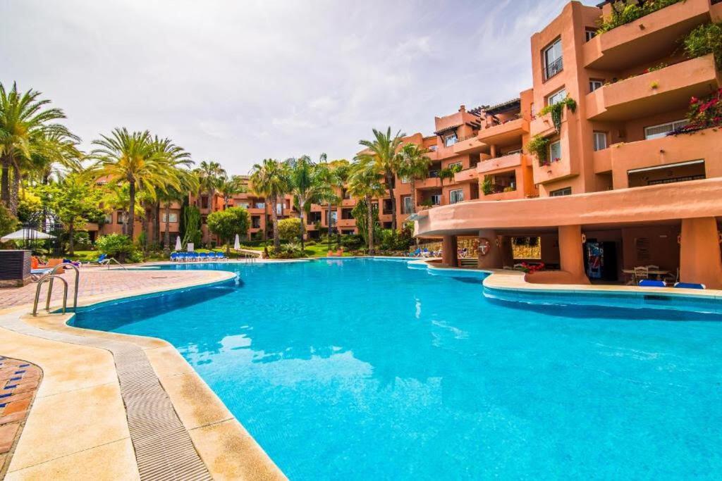 a large swimming pool in front of a building at Oasis 3 bedroom Marbella Golden Mile in Marbella
