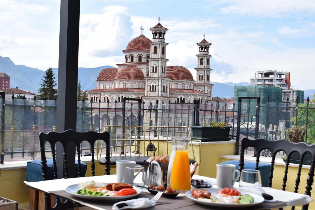 a table with plates of food on top of a building at Bocca Hotel Korce in Korçë