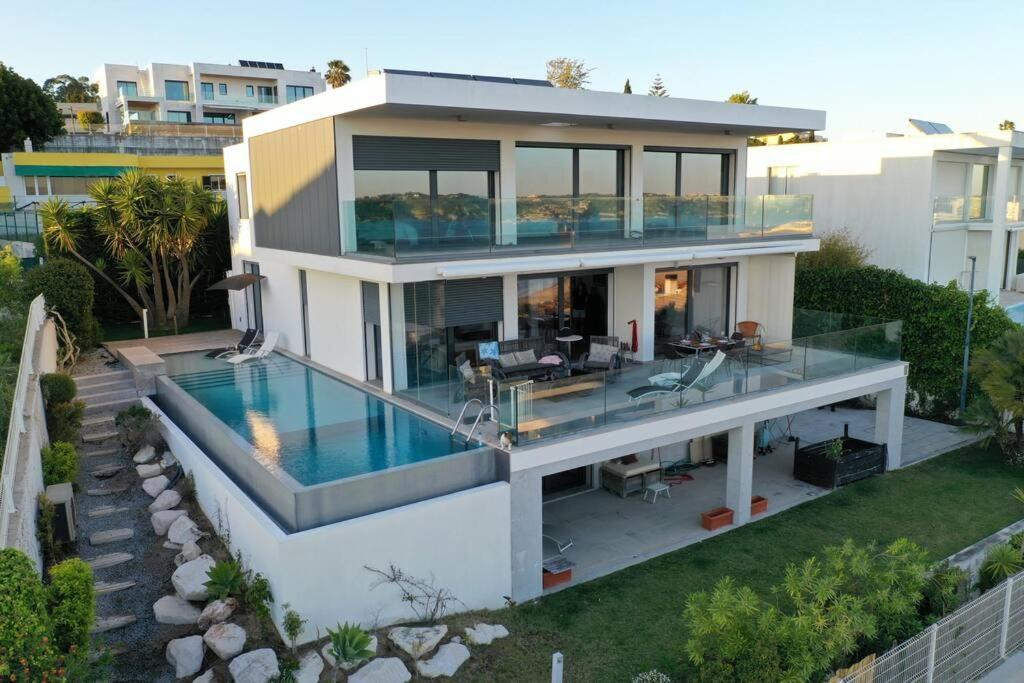 Modern Villa with Sea & River View Pool and Gym. في لشبونة: اطلالة جوية على منزل مع مسبح