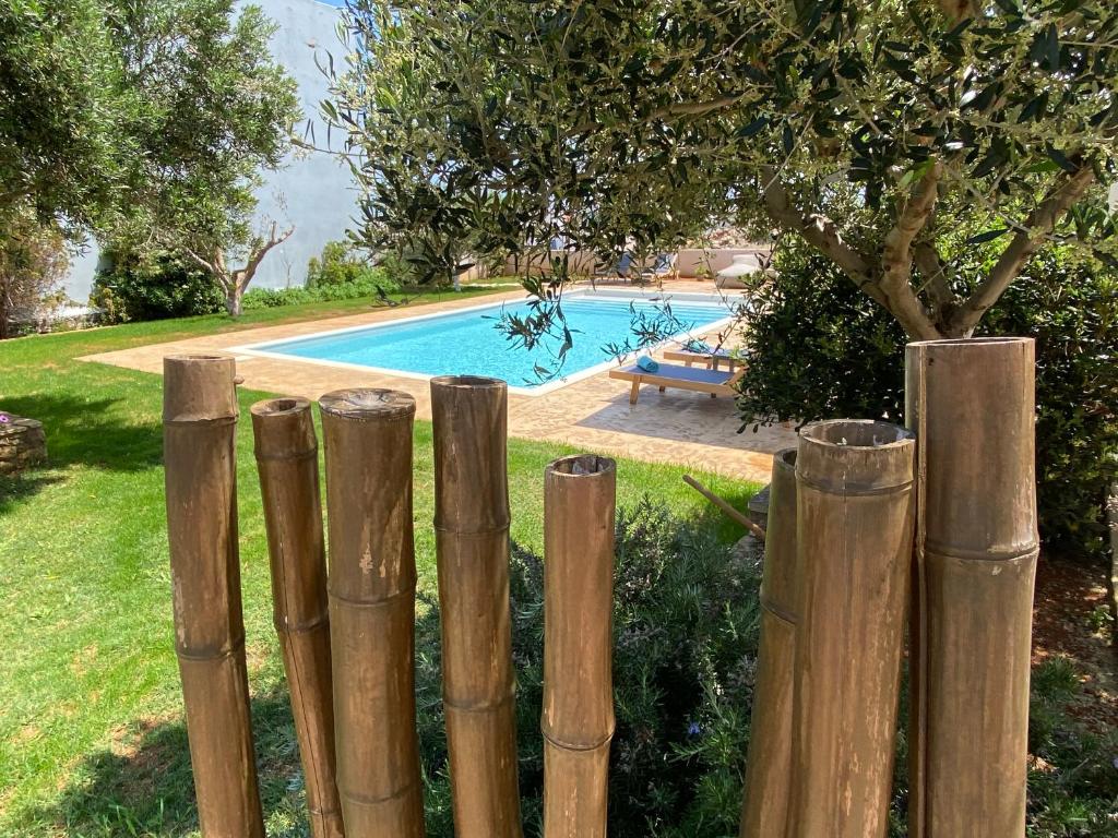 una recinzione di legno di fronte alla piscina di Sirene Villas a Diakofti