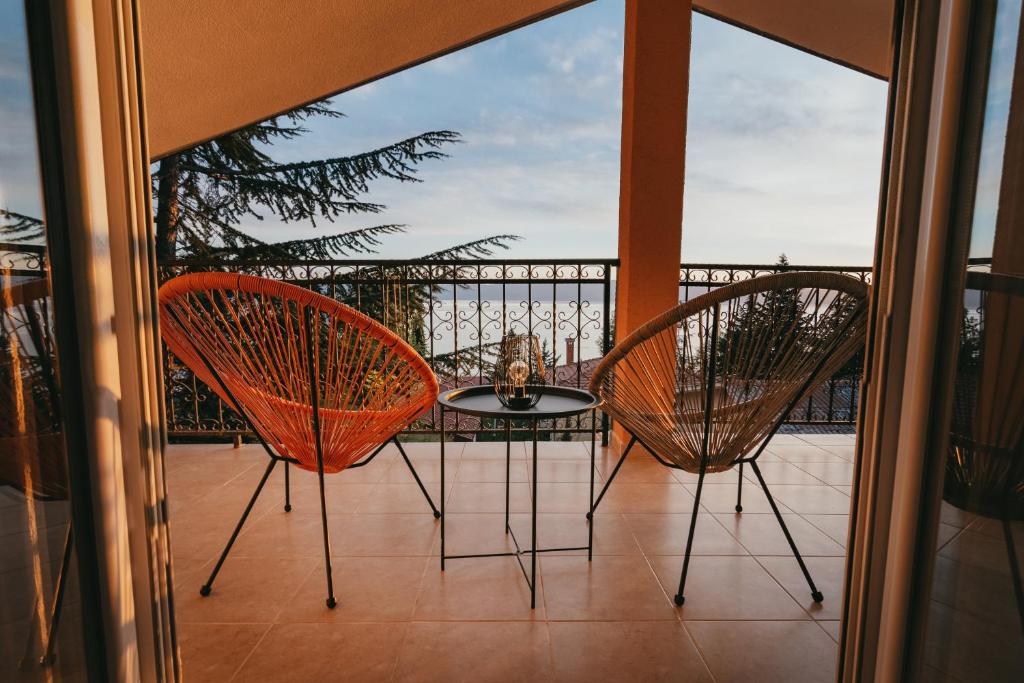 a balcony with two chairs and a table on a balcony at Villa Pandora in Ohrid