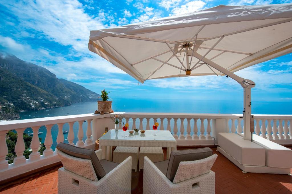 a balcony with a table and chairs and an umbrella at Villa Briganti Seaview Terrace in Positano