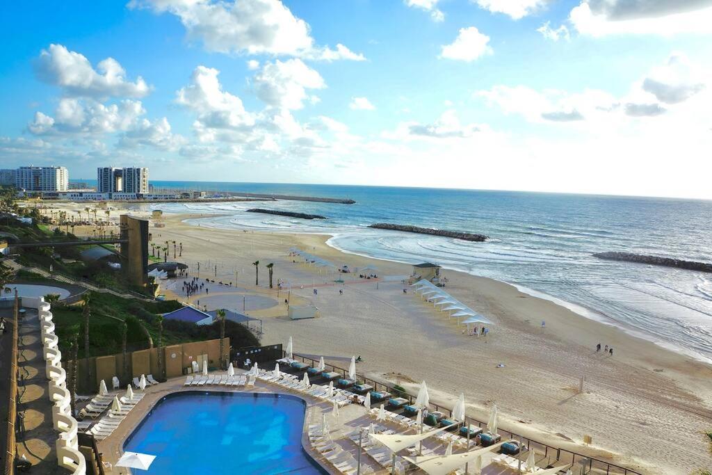 uma vista para uma praia com uma piscina e o oceano em Daniel Hotel - Residence Seaside Luxury Flat em Herzeliya