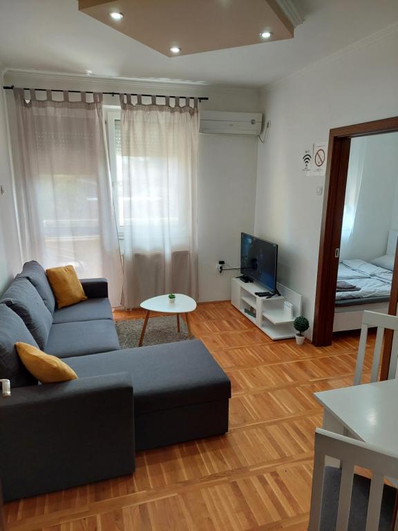 a living room with a couch and a tv at Smiley 2 - Subotica Centar in Subotica