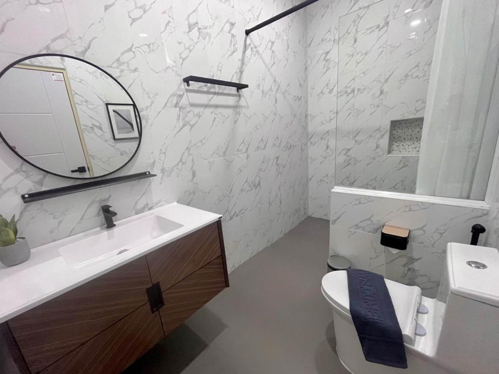 La salle de bains est pourvue d'un lavabo, d'un miroir et de toilettes. dans l'établissement 373 pool villa, à Chiang Rai