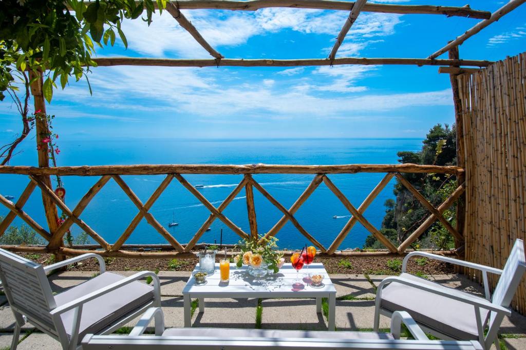 a table and chairs with a view of the ocean at Villa Briganti Seaview Terrace in Positano