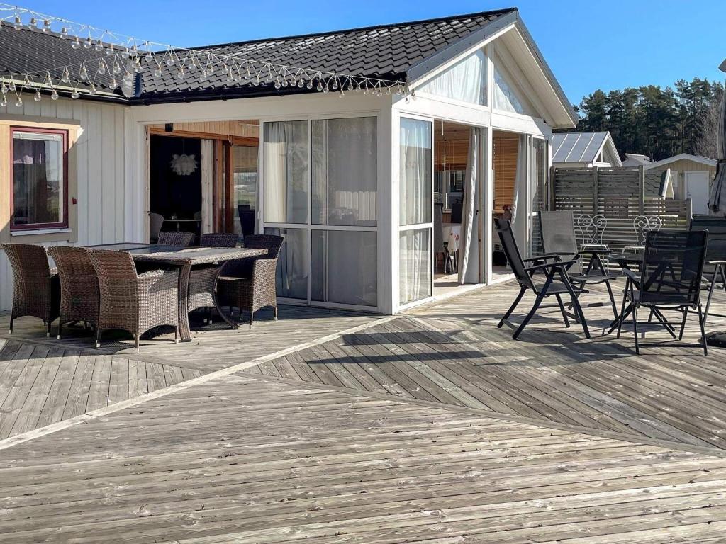 une terrasse en bois avec une table et des chaises sur une maison dans l'établissement Holiday home HJO IV, à Hjo