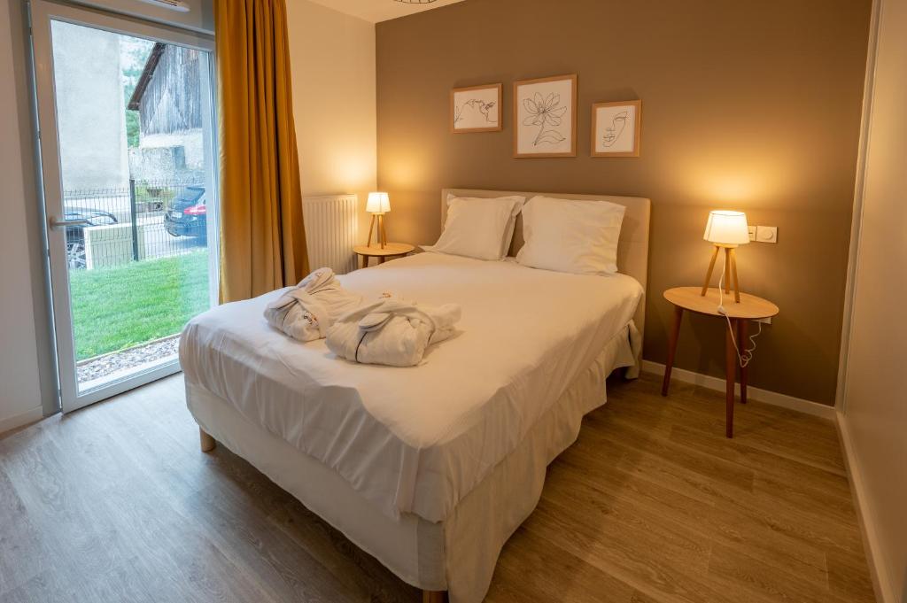 sypialnia z łóżkiem z 2 lampami i oknem w obiekcie DOMITYS L'HOROLOGIA w mieście Cluses
