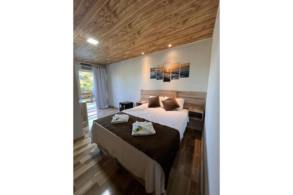 um quarto com uma cama com duas toalhas em OYO Pousada Coisa Mais Linda em Iguape