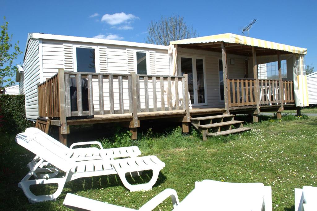 ein Haus mit einer Terrasse mit einer Bank und einer Veranda in der Unterkunft Mobil home luxe 8 personnes avec wifi in Onzain