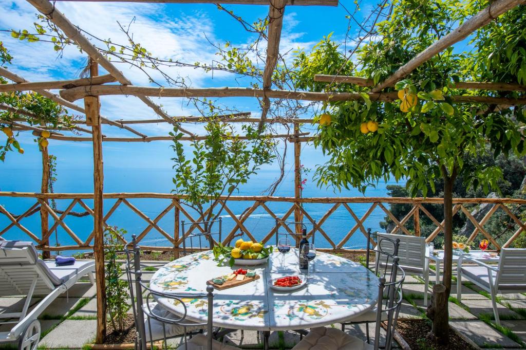 a table with a bowl of fruit sitting on top of a patio at Villa Briganti Seaview Terrace in Positano