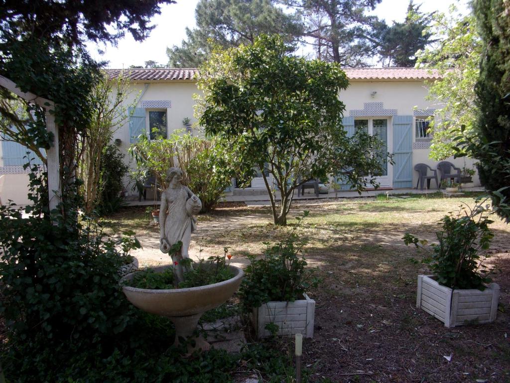 una estatua en un jardín frente a una casa en mas des pins, en Saint-Cyprien