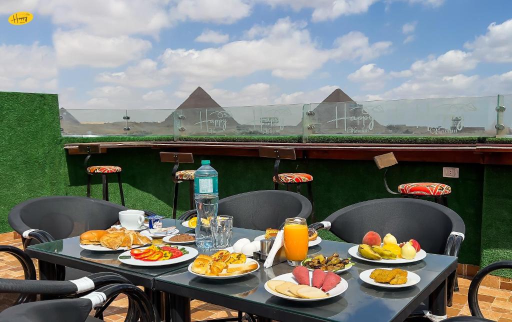 a table with plates of food and drinks on it at Happy View Inn in Cairo