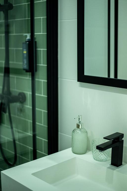 a bathroom with a sink with a shower and a mirror at Olive Boutique Guesthouse in Vila Franca do Campo