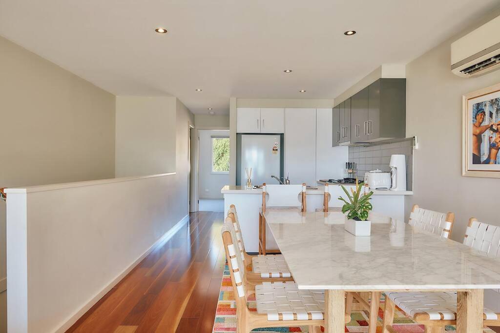 a kitchen and dining room with a table and chairs at Vine Close Apartment in Healesville