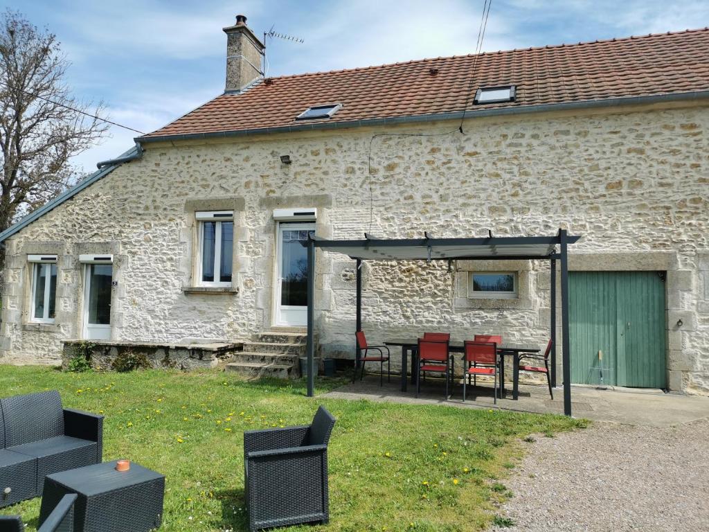 a patio with chairs and a table in front of a building at La fermette des Étangs in Crux-la-Ville