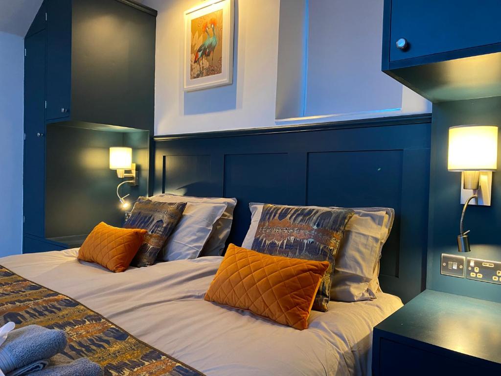 um quarto com uma cama com almofadas laranja em Tiny home, the Wye Valley, Clanna Cottage Llandogo em Llandogo