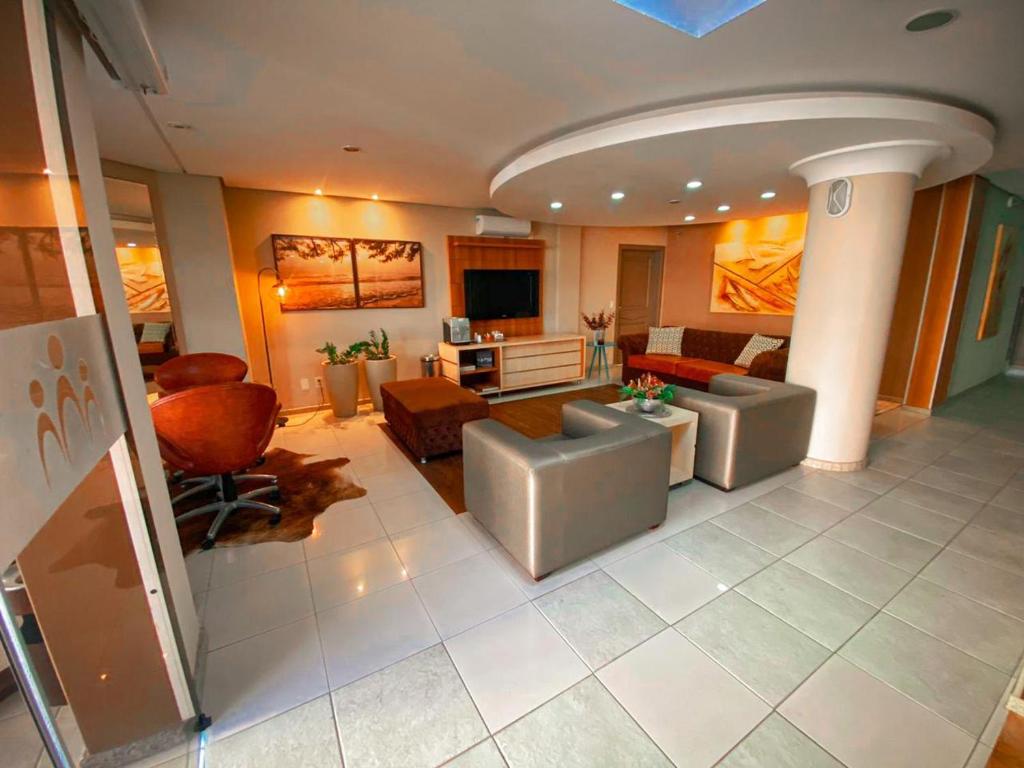 una gran sala de estar con sofás y TV. en Diaudi Hotel, en São José