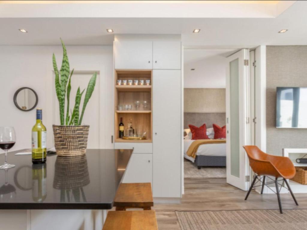 a kitchen and living room with a table and a bed at Edgy On Bree in Cape Town