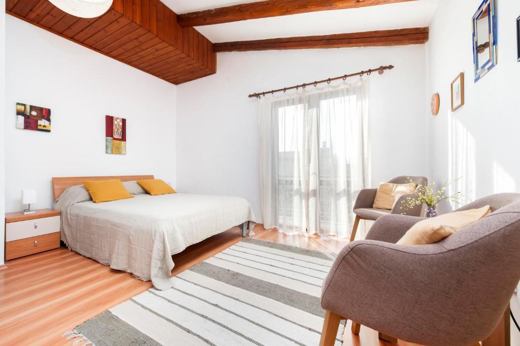 a bedroom with a bed and two chairs in it at Studio and Room Tea in Rovinj