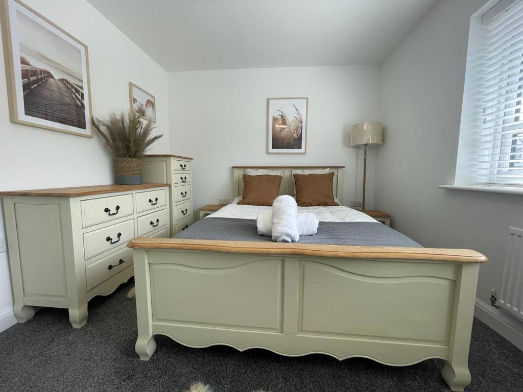 a bedroom with a bed and a dresser at Barry Waterfront Stays - ENTIRE 3 BED PROPERTY in Barry