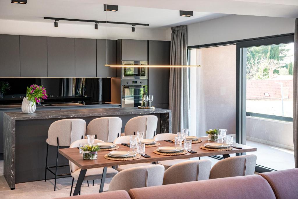 "Villa AnMari" The Cavtat View Residence في كافتات: مطبخ وغرفة طعام مع طاولة وكراسي