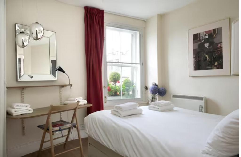 a bedroom with a bed and a desk and a window at Royal Mile Apartment, 1 minute from the castle. in Edinburgh