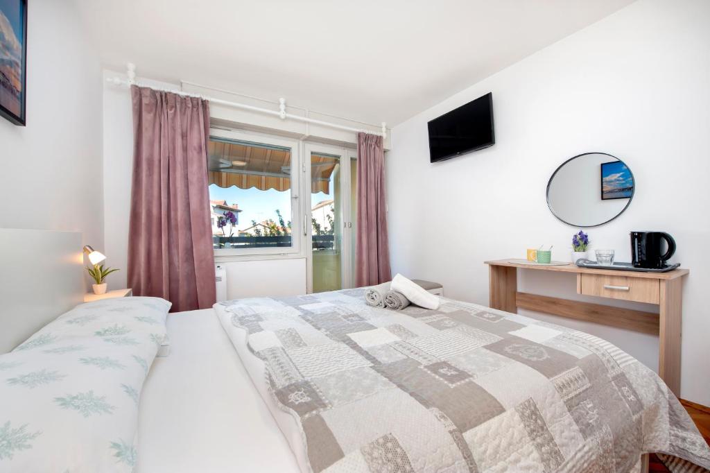 Schlafzimmer mit einem Bett und einem Fenster in der Unterkunft Casa Caterina in Rovinj