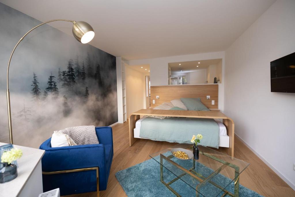 a bedroom with a bed and a blue chair at ArtRoom Boarding Apartment in Bissendorf