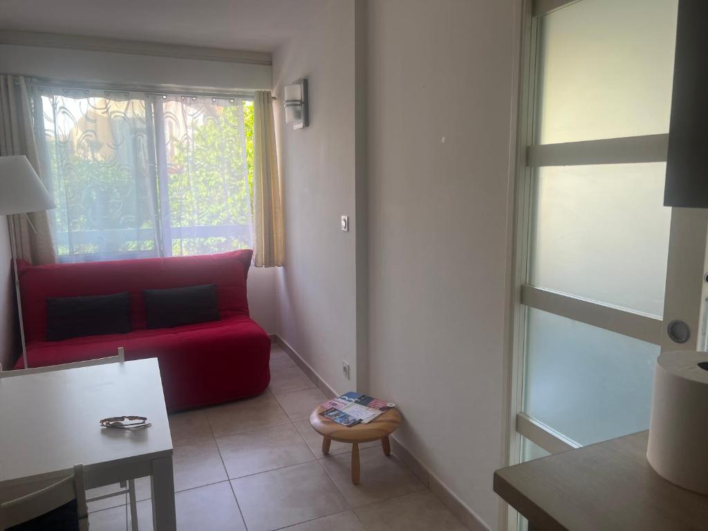 ein Wohnzimmer mit einem roten Sofa und einem Fenster in der Unterkunft Appartement à Bandol in Bandol