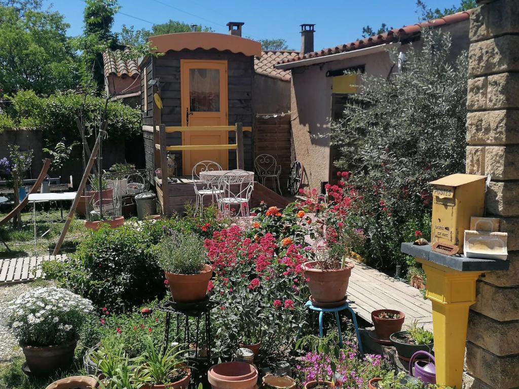 un jardin avec des fleurs et des plantes devant une maison dans l'établissement la fée viviane et michel l'enchanteur, à Robion