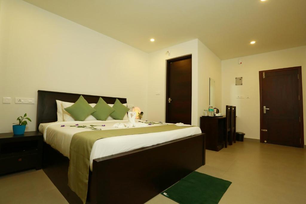a bedroom with a large bed and a bathroom at SATRA WAYANAD in Kalpetta