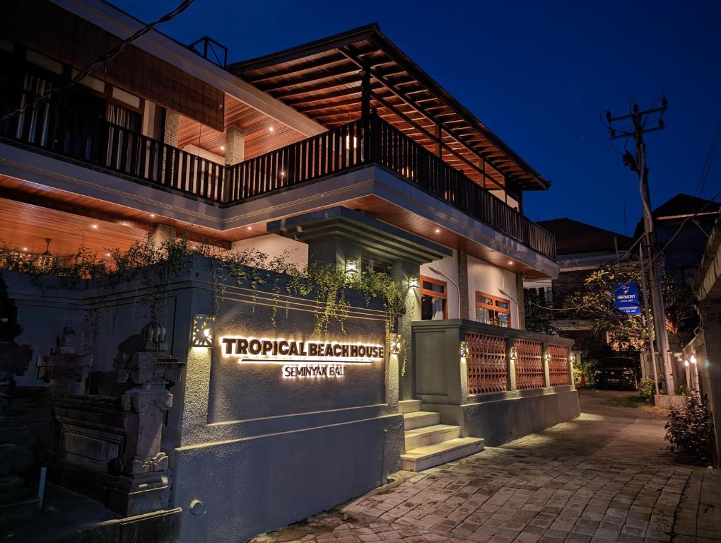 a building with a sign on the side of it at Tropical Beach House Bali in Seminyak