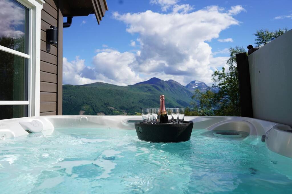 a hot tub with a bottle of wine and glasses at Panorama View in Stranda