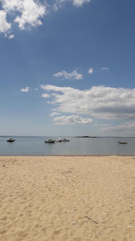 una playa de arena con barcos en el agua en Mobil-home dans camping calme, en Pénestin