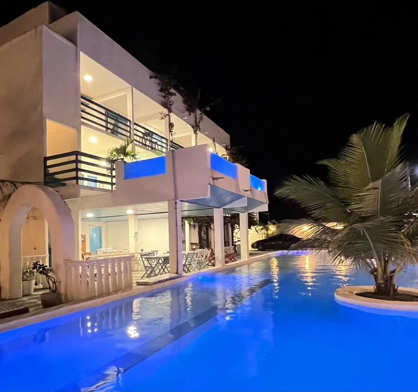 uma villa com piscina à noite em Pousada La Grécia em Camocim