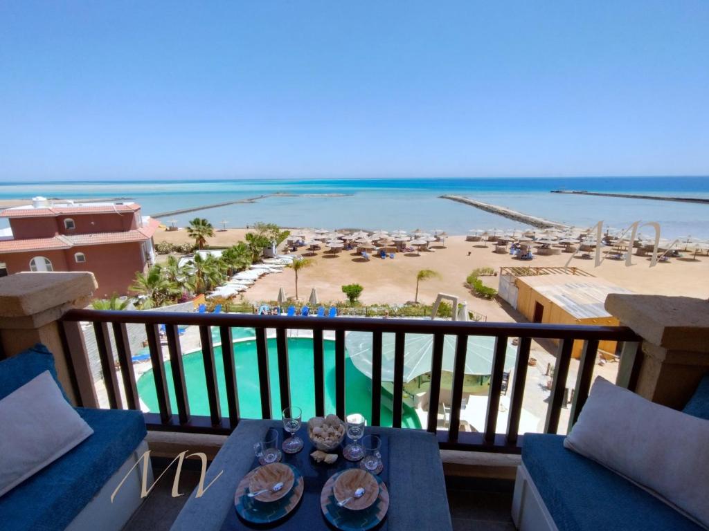 uitzicht op het strand vanaf het balkon van een resort bij Exclusive Sea View Apartments Hurghada in Hurghada
